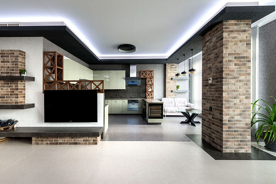 Woonkamer met een bakstenen accentwand, ingebouwde haard en een lichtplafond langs de randen